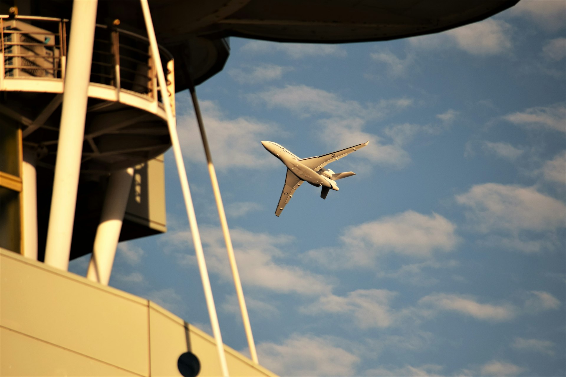 an airplane flying in the air over a building